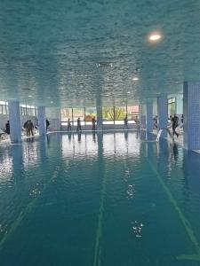 ein Wasserpool mit Leuten in einem Gebäude in der Unterkunft Căsuța Bunicilor in Dorna Cîndrenilor