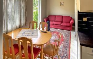 uma sala de estar com uma mesa e um sofá vermelho em 2 Bedroom Gorgeous Apartment In Eresfjord em Nauste