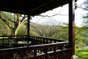 a porch with a table and a view of the forest at Borinquen Thermal Resort in Liberia