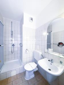 a bathroom with a sink and a toilet and a shower at Schlosshotel Marienbad in Mariánské Lázně