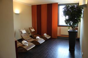 斯圖加特的住宿－施泰根博閣格拉夫齊柏林酒店，一间房间,配有三把棕色椅子和盆栽植物