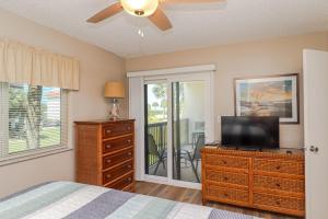 een slaapkamer met een bed en een tv op een dressoir bij Ocean Village Club P23 in St. Augustine