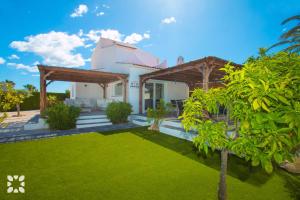 カルプにあるVilla Los Almendros by Abahana Villasの前の緑の芝生の家