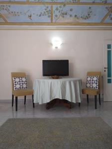 - une télévision assise au-dessus d'une table avec 2 chaises dans l'établissement L'Orto di Sant'Andrea, à Pise