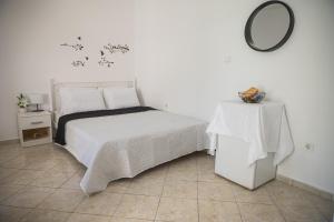a bedroom with a bed and a table with a mirror at Happy Room-2' from sea in Kalamata