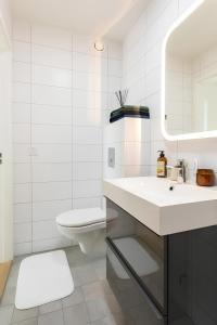 uma casa de banho branca com um lavatório e um WC em The Luxurious Lakeview Villa near Stockholm em Estocolmo