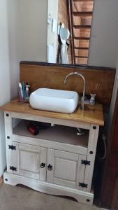 um toucador de casa de banho com um lavatório e um espelho. em Hospedagem Cabanas do Lago Urubici em Urubici