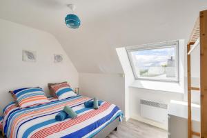 a bedroom with a bed and a window at 1er étage, jardin partagé pour 4 à 300m de la plage in Le Guilvinec