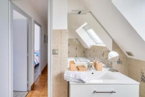 a bathroom with a sink and a skylight at 1er étage, jardin partagé pour 4 à 300m de la plage in Le Guilvinec +8 photos