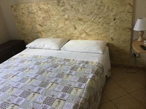 um quarto com uma cama e uma parede de pedra em Achirina bed and breakfast em Cisterna di Latina