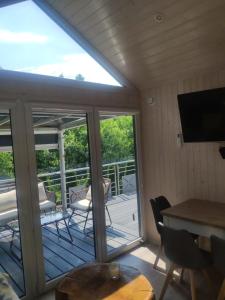 a screened in porch with a television and a table and chairs at Słoneczny Zakątek nad Doliną Słupi in Grabno