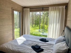 a bedroom with a bed and a large window at WALD Villas - Aavasaksa, Lapland in Aavasaksa