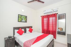 a bedroom with a bed and a red curtain at Collection O Royal Mac in Bangalore +18 photos