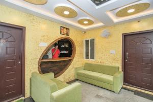 une chambre avec deux chaises, un canapé et un miroir dans l'établissement Manyata Royal Mac, à Bangalore