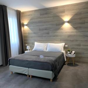a bedroom with a bed and a wooden wall at Boutique Hotel Nuovo Cason in Cavallino-Treporti