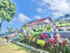 a house with a bunch of plants in front of it at Highland Santi Homestay in Besakih