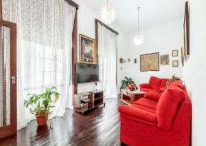 ein Wohnzimmer mit einem roten Sofa und einem TV in der Unterkunft 3 bedrooms house with wifi at Santa Cruz de la Palma in Santa Cruz de la Palma