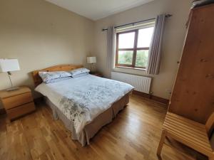 um quarto com uma cama grande e uma janela em Roadside Cottage The Burren Kilfenora County Clare em Kilfenora