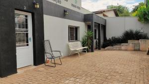 a bench sitting outside of a building with a door at Pousada Sonho in Apucarana