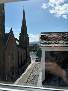a view from a window of a church with a tower at Hootananny in Inverness