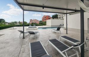 a patio with chairs and a swimming pool at Gorgeous Home In Podstrana With Wifi in Podstrana