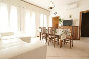 - un salon avec une table, des chaises et une télévision dans l'établissement 12 Accesso - Home Immobiliare Jesolo, à Lido di Jesolo