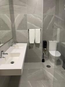 een badkamer met een witte wastafel en een toilet bij Areosa in Porto