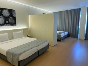 een hotelkamer met een bed en een bed en een kast bij Areosa in Porto