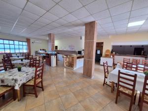 um restaurante com mesas e cadeiras e uma cozinha em Palma Beach Hotel em Kranevo