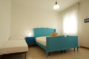 - une chambre avec 2 lits bleus et une fenêtre dans l'établissement 12 Accesso - Home Immobiliare Jesolo, à Lido di Jesolo