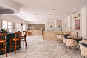 uma grande sala com mesas e cadeiras e uma cozinha em Katerina Hotel em Agia Marina