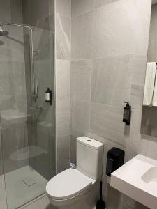 een badkamer met een toilet, een douche en een wastafel bij Areosa in Porto