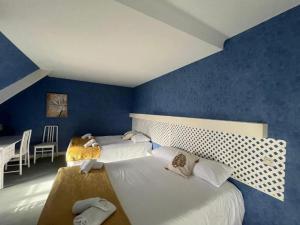 Duas camas num quarto com paredes azuis em Hôtel Le Phare em Ouistreham