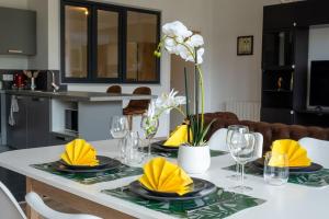 a dining room table with yellow napkins and plates on it at Charme de Bollwiller in Bollwiller