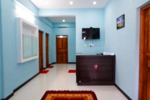 korytarz z niebieskimi ścianami, telewizorem i dywanem w obiekcie Angel Holidays w mieście Munnar