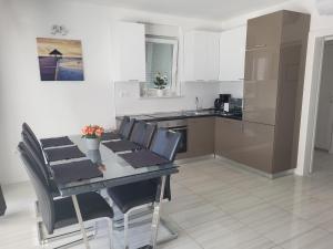 kuchnia ze stołem i krzesłami oraz kuchnia z blatem w obiekcie Apartment Villa Lumada with Pool w Novalji
