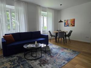 uma sala de estar com um sofá azul e uma mesa em Central stylish apartment em Braunau am Inn