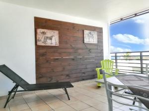 uma varanda com um banco, uma mesa e cadeiras em Appartement de 2 chambres a Saint Pierre a 600 m de la plage avec vue sur la mer piscine partagee et terrasse amenagee em Saint-Pierre