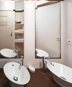 uma casa de banho com 2 lavatórios e um espelho grande em Appartement de 2 chambres a Saint Pierre a 600 m de la plage avec vue sur la mer piscine partagee et terrasse amenagee em Saint-Pierre