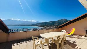 a table and chairs on a balcony with a view of the ocean at Appartement SANTA REGINA 3 Calvi in Calvi