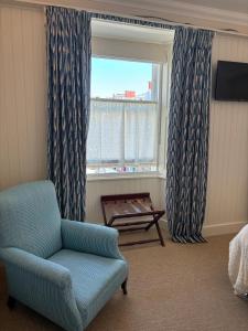 a living room with a chair and a window at Hootananny in Inverness