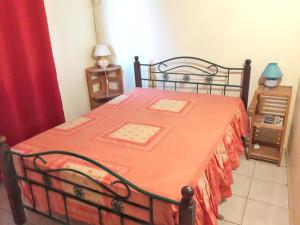 una camera con un letto e una coperta arancione di Maison de 2 chambres avec vue sur la mer terrasse amenagee et wifi a Petit Bourg a 3 km de la plage a Petit-Bourg