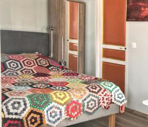 een slaapkamer met een bed met een kleurrijke quilt bij Studio avec balcon amenage et wifi a Sainte Suzanne in Sainte-Suzanne