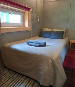 a bed with two blue towels on it in a room at Vastseliina Metskond Camping in Vahtseliina