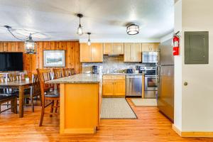 a kitchen with wooden cabinets and a table with chairs at Winter Park Condo w/ Resort Shuttle On-Site! in Winter Park