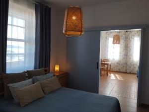 a bedroom with a blue bed and a dining room at Aegina Port Apt 2-Διαμέρισμα στο λιμάνι της Αίγινας 2 in Aegina Town