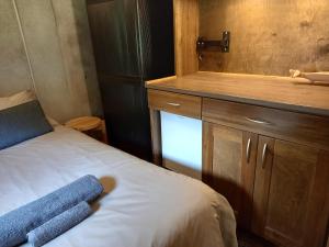 a small bedroom with a bed and a sink at Vastseliina Metskond Camping in Vahtseliina