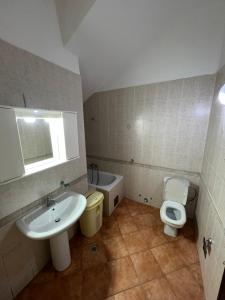 uma casa de banho com um lavatório e um WC em Renome em Petrovac na Moru