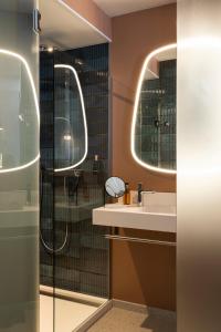 a bathroom with a sink and two mirrors at Oceania Saint Malo in Saint Malo
