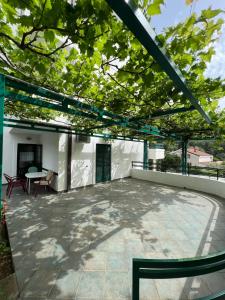 a patio with a table and chairs on a roof at Renome in Petrovac na Moru